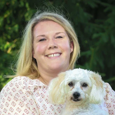 Chiropractor Amy Hershberger Smiles Warmly at the Viewer with her Dog